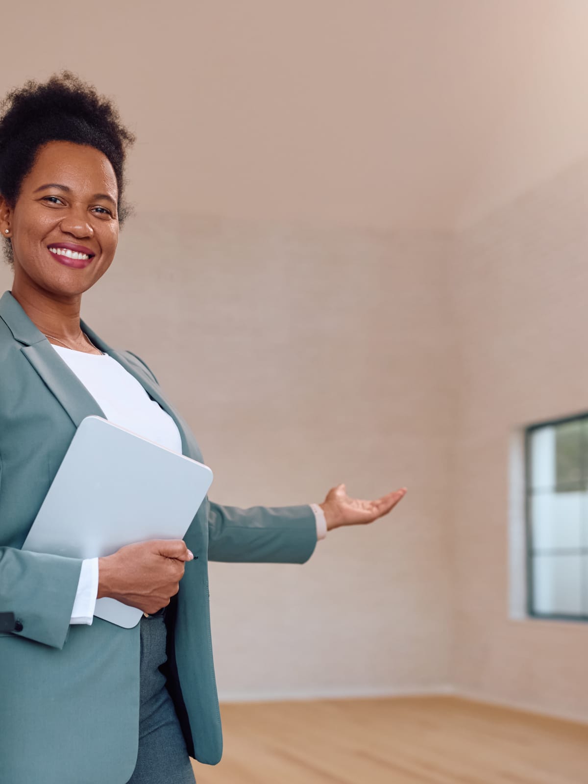 Best World agent in a tailored blazer welcoming a buyer into an empty home